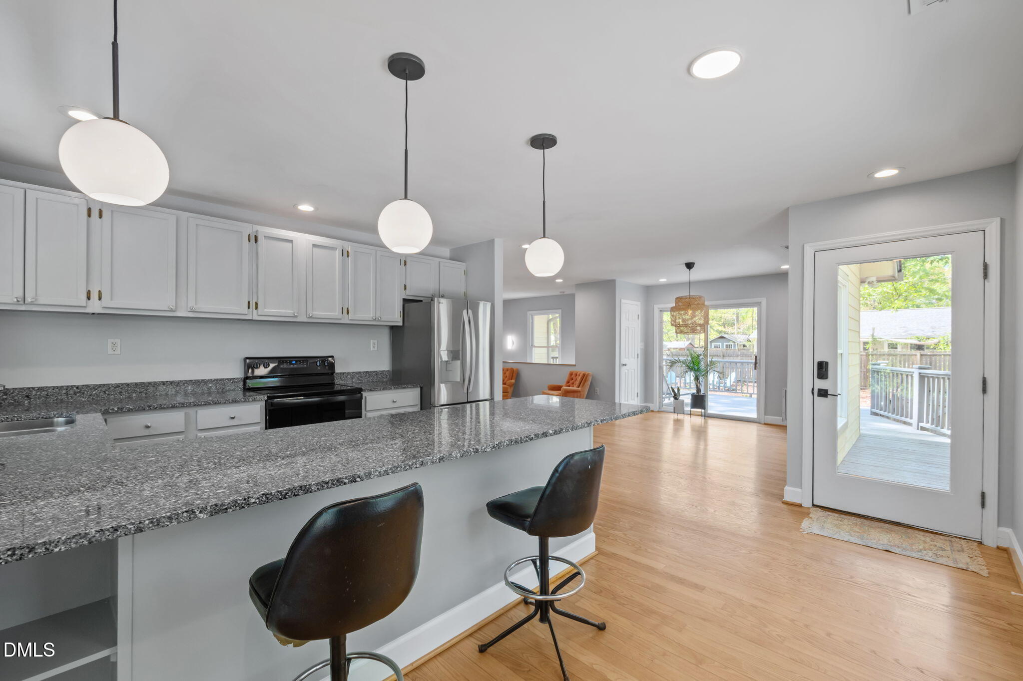 201 Simpson Street, Unit B Carrboro, NC 27510 - Photo 3 of 56 a large kitchen with granite countertop a stove a sink a oven a dining table and chairs with wooden floor