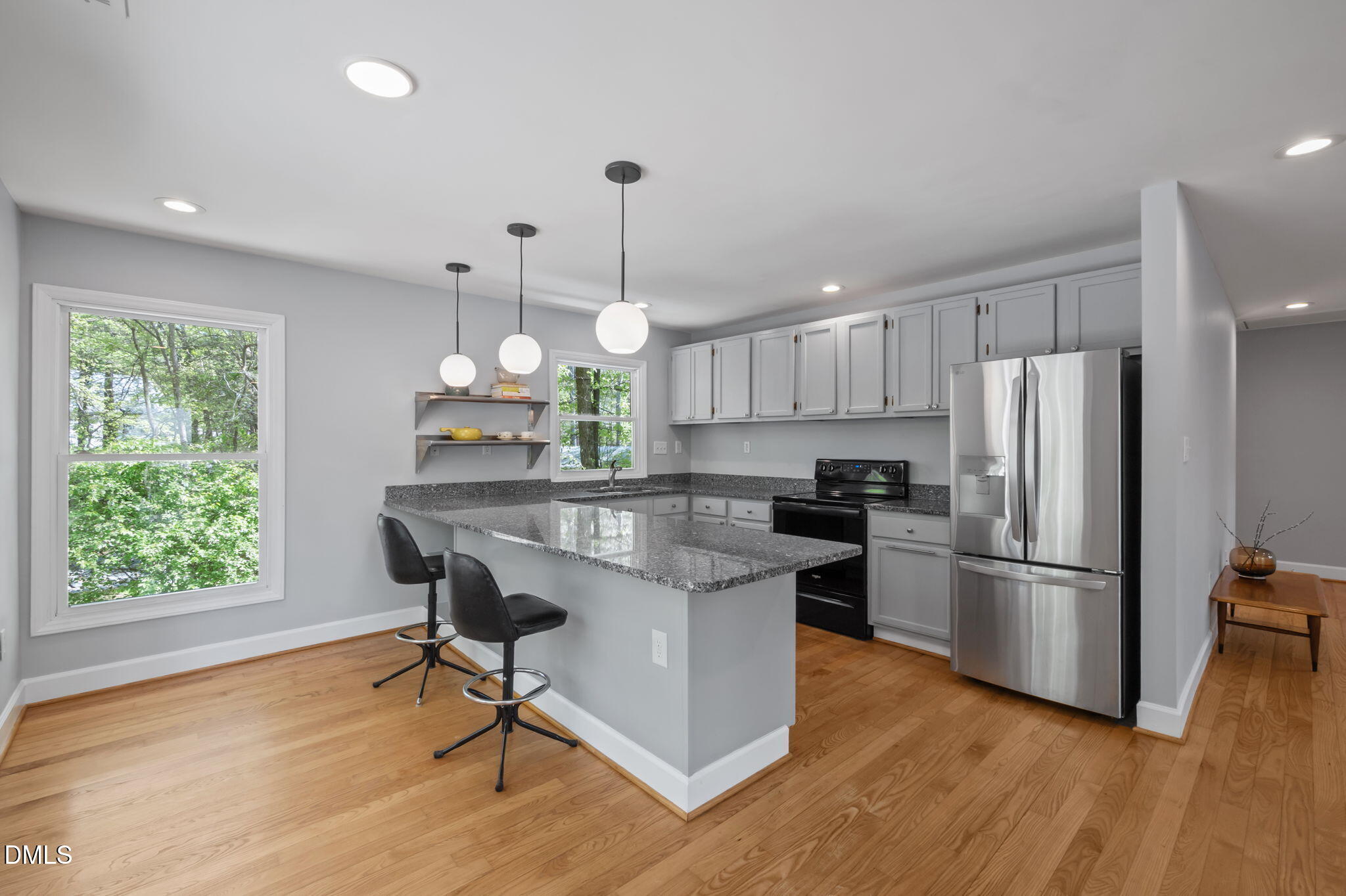 201 Simpson Street, Unit B Carrboro, NC 27510 - Photo 8 of 56 a kitchen with stainless steel appliances granite countertop wooden floor a refrigerator a sink a stove a dining table and chairs