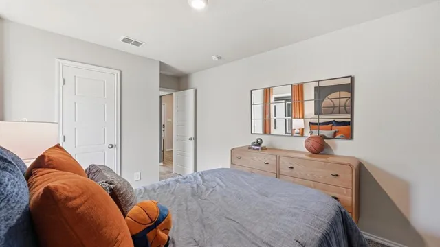 a bedroom with a bed and a lamp next to a window