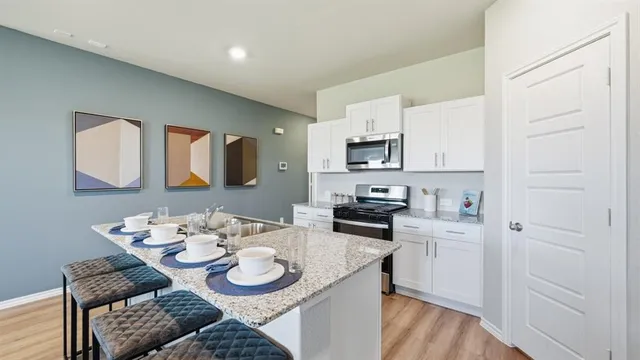 a view of a dining room and kitchen with furniture wooden floor and a chandelier