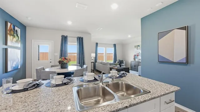 a dining hall with stainless steel appliances granite countertop a granite counter tops and a wooden floors