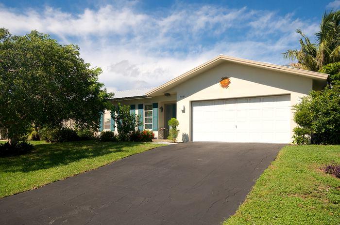 4881 Northwest 5th Terrace Boca Raton, FL 33431 - Photo 1 of 13 a front view of a house with a yard and garage