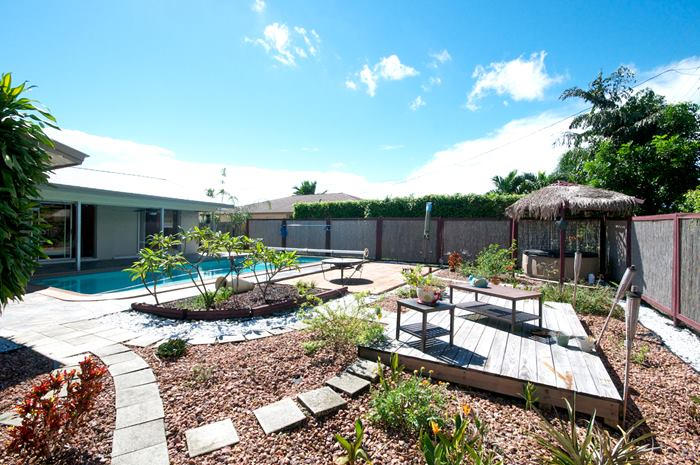 4881 Northwest 5th Terrace Boca Raton, FL 33431 - Photo 3 of 13 a view of a patio with couches table and chairs under an umbrella with potted plants