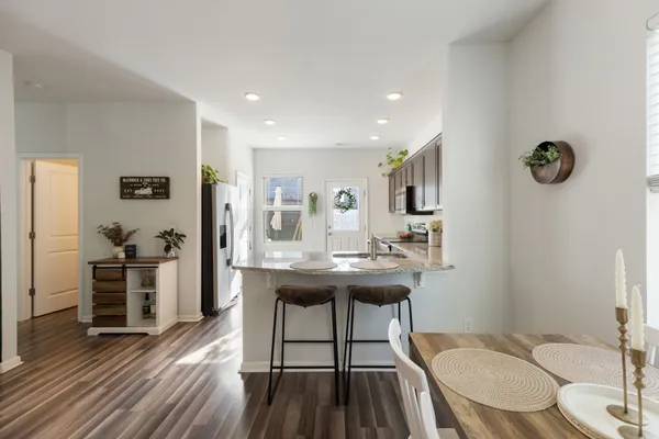 a view of a kitchen area with furniture and wooden floor