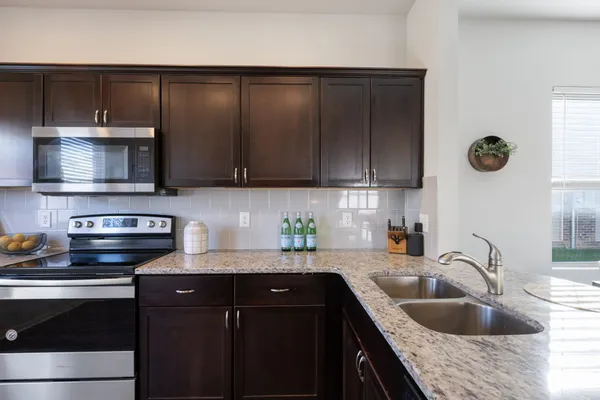 a kitchen with a sink a stove and cabinets