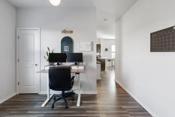 a view of a workspace with furniture and wooden floor