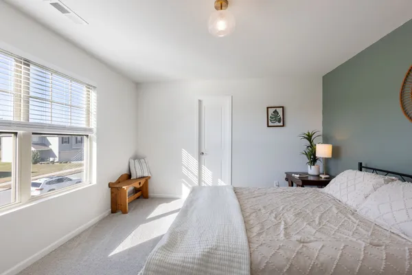 a bedroom with a bed and a large window