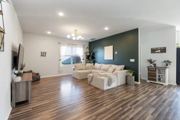 a living room with furniture flat screen tv and couches