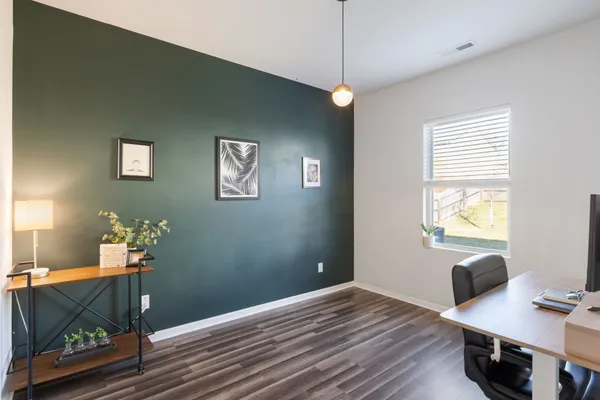 a view of a workspace with furniture and a window
