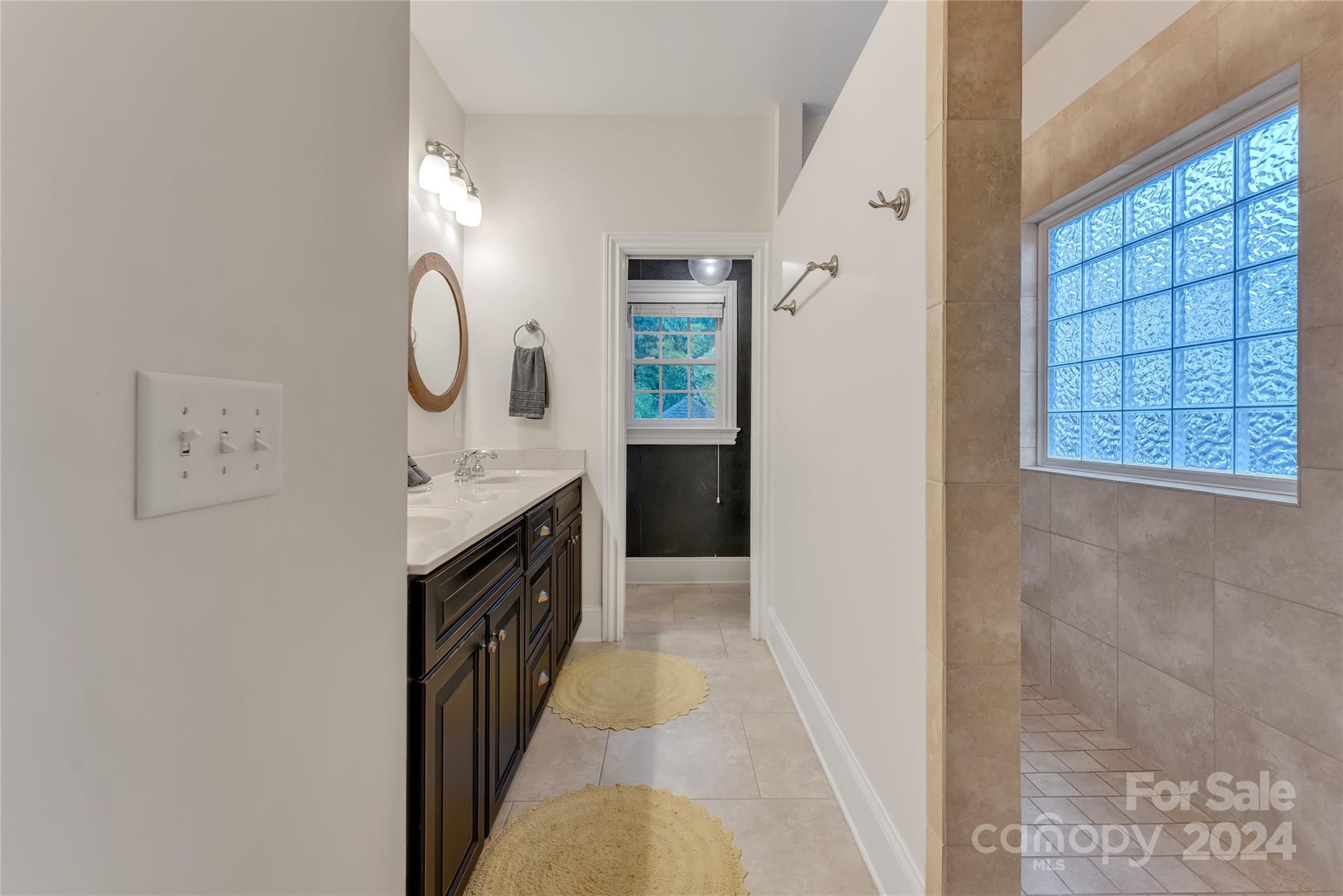 920 Millbrook Road Charlotte, NC 28211 - Photo 27 of 48 a spacious bathroom with a double vanity sink a toilet and a window