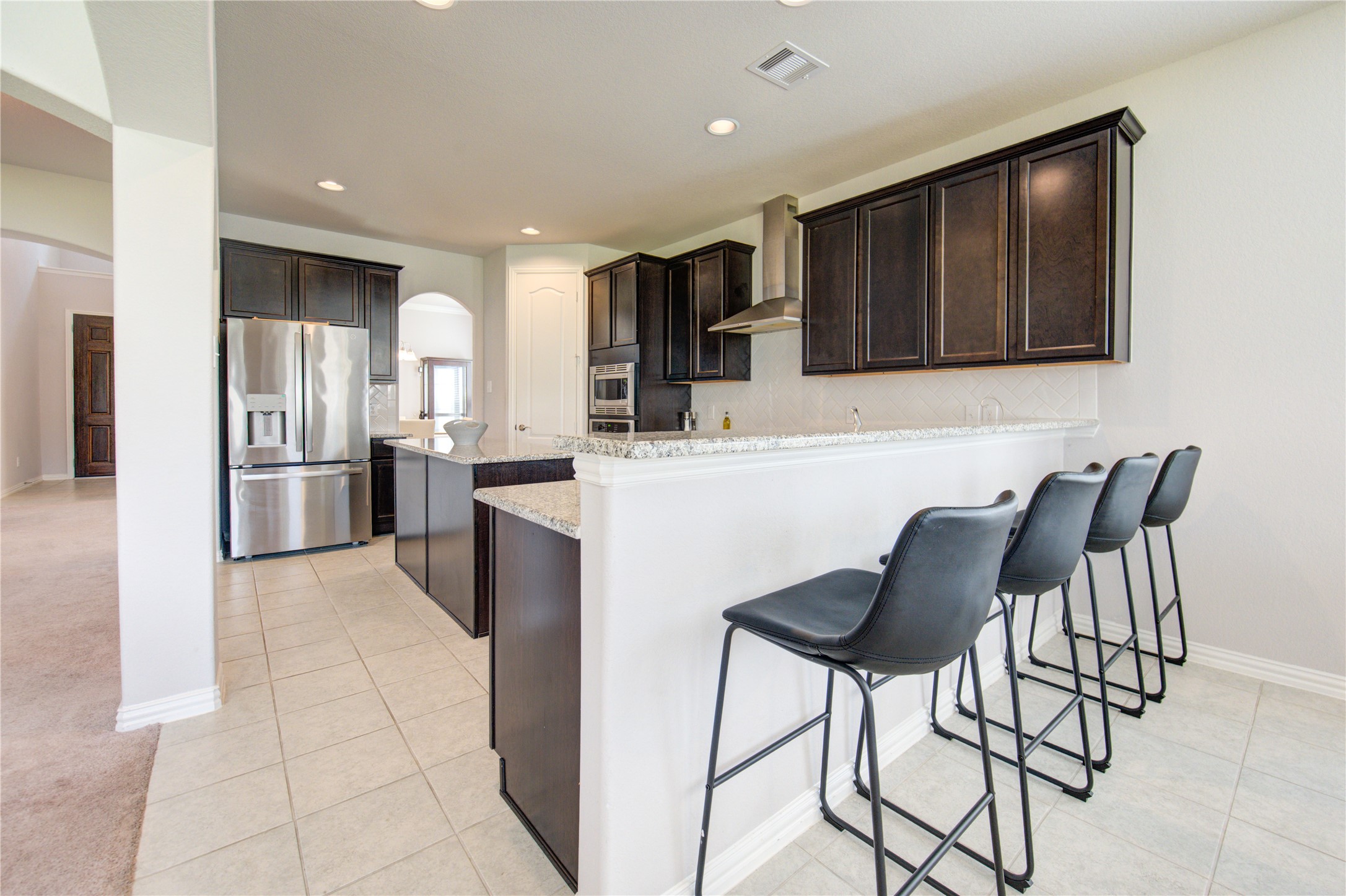 13838 Sturcombe Gln Trail Rosharon, TX 77583 - Photo 16 of 44 a kitchen with stainless steel appliances kitchen island granite countertop a refrigerator and a stove top oven