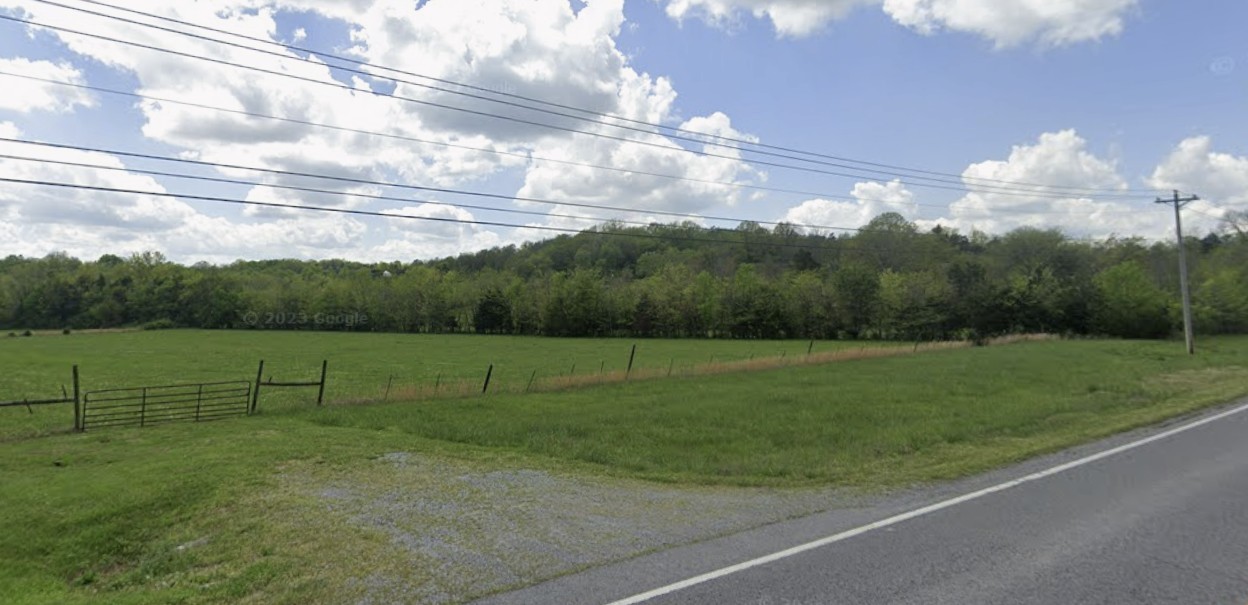 a view of outdoor space with green field and trees