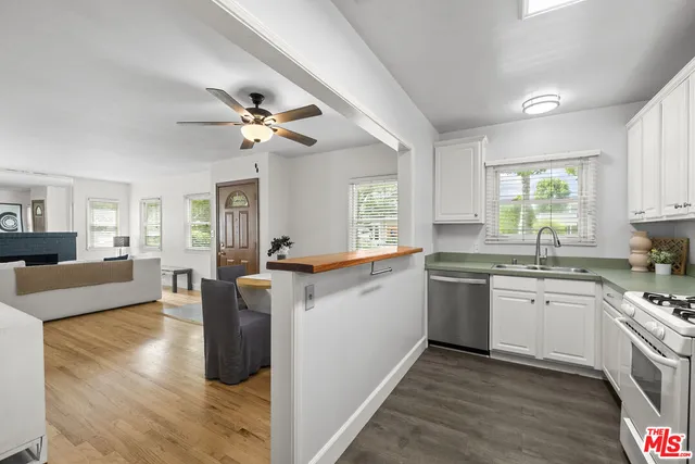 a kitchen with kitchen island granite countertop a sink cabinets and window