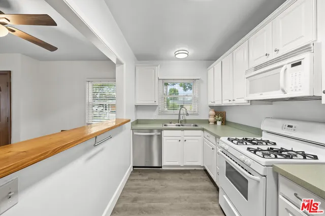a kitchen with a sink stove top oven and cabinets