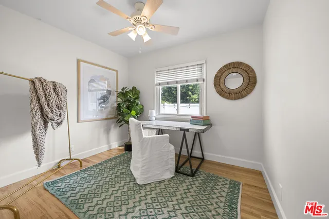 a view of a workspace with furniture and a window