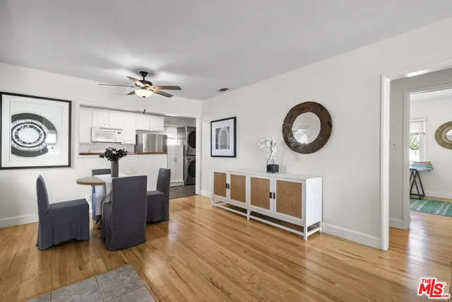 a living room with furniture a clock and wooden floor