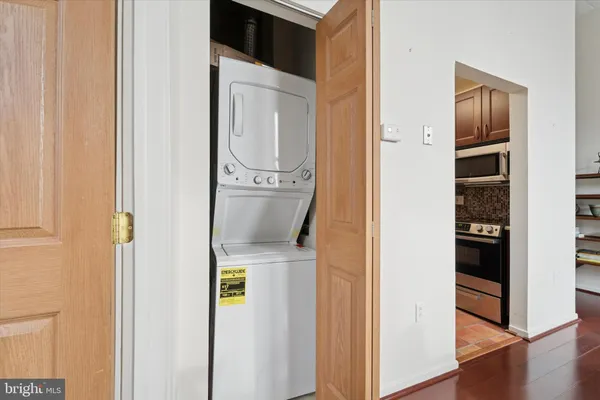 a picture of a room with wooden floor washer and dryer