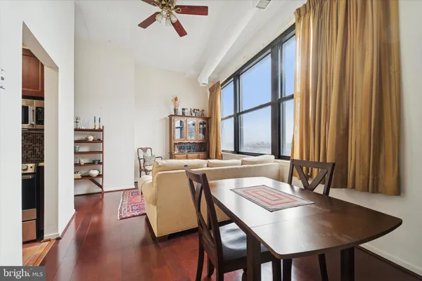 a living room with furniture a large window and wooden floor
