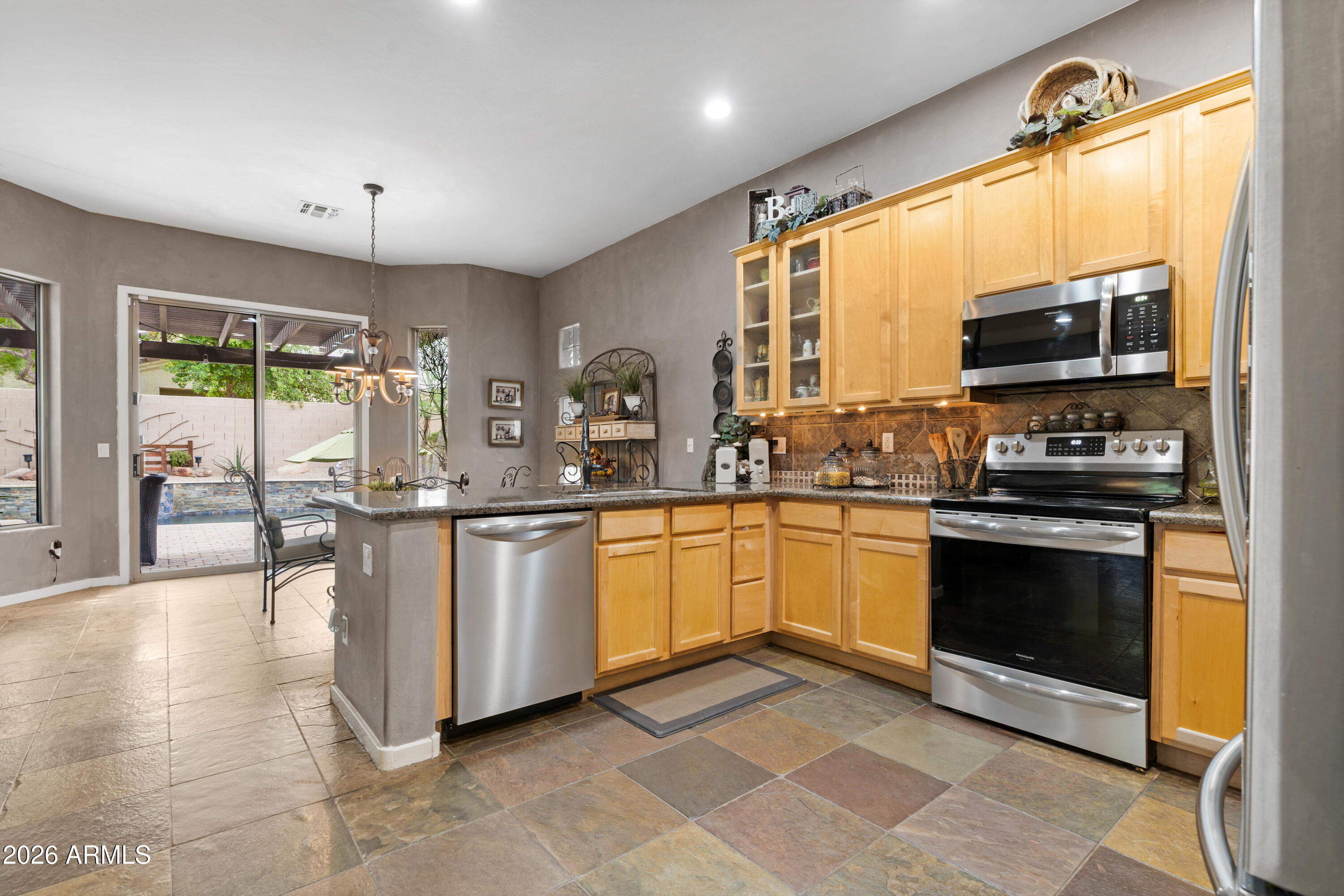 2107 East Beautiful Lane Phoenix, AZ 85042 - Photo 12 of 36 a kitchen with stainless steel appliances granite countertop a stove a sink and a microwave