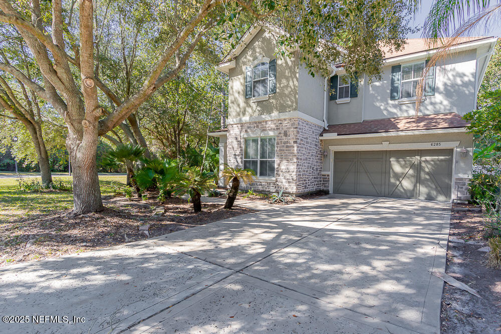 a view of a house with backyard and trees