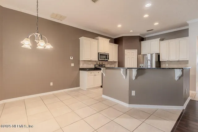 a kitchen with stainless steel appliances granite countertop a refrigerator and a stove top oven