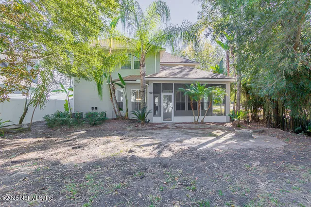 a view of a swimming pool with lawn chairs under an umbrella