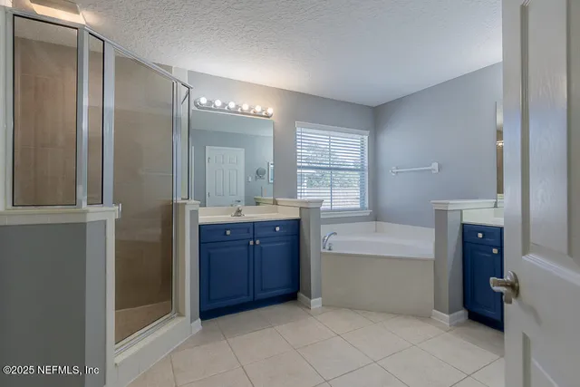 a bathroom with a tub sink vanity and mirror