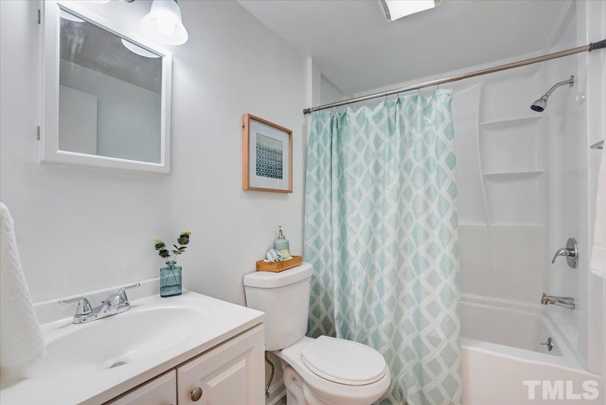 424 Grovemont Road Raleigh, NC 27603 - Photo 17 of 23 a bathroom with a sink a toilet and shower curtain