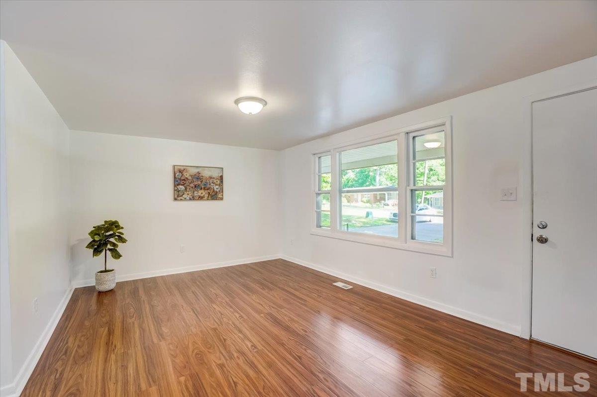 424 Grovemont Road Raleigh, NC 27603 - Photo 4 of 23 wooden floor in an empty room with a window