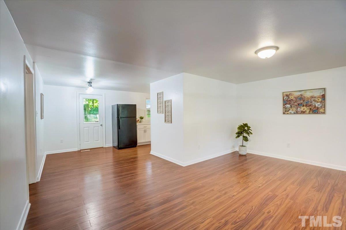 424 Grovemont Road Raleigh, NC 27603 - Photo 7 of 23 a view of an empty room with wooden floor and a window