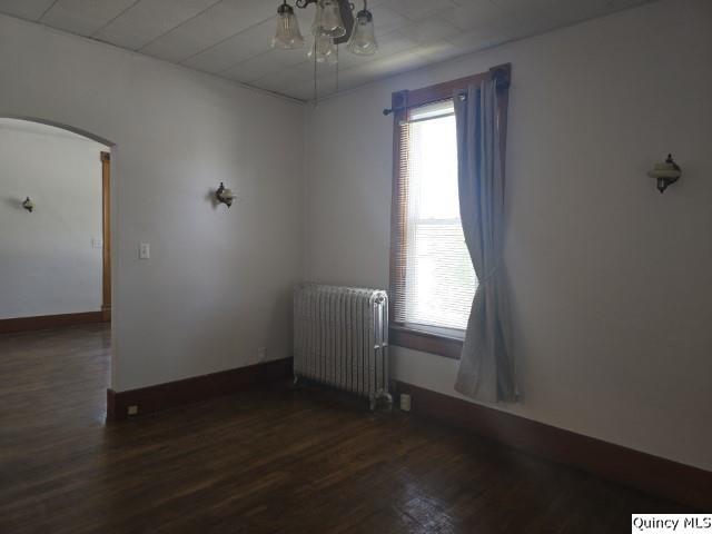 210 Main Street Carthage, IL 62321 - Photo 6 of 36 an empty room with wooden floor and windows