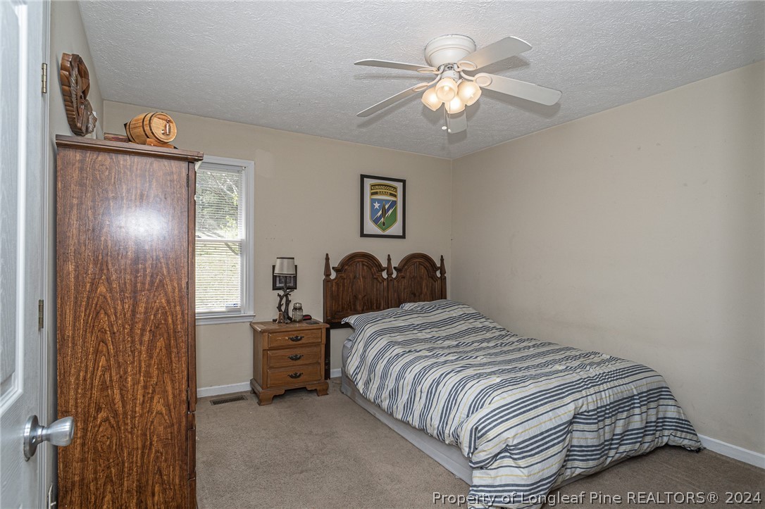 1955 Christopher Way Fayetteville, NC 28303 - Photo 26 of 35 a bedroom with a bed and a chandelier
