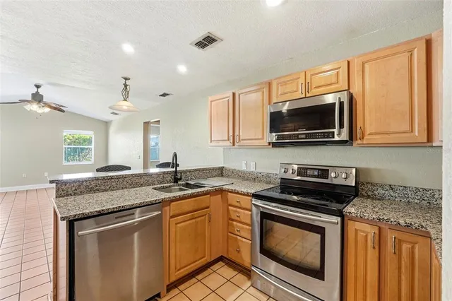 a kitchen with kitchen island granite countertop a sink a counter top space and cabinets