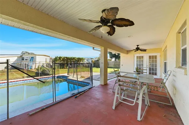 a view of a patio with a table chairs and a swimming pool