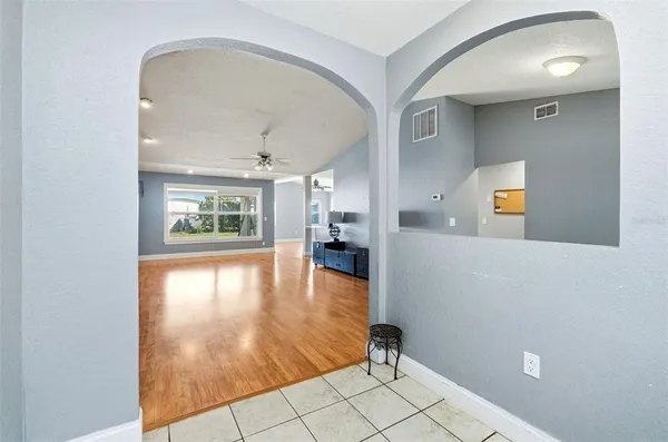 a view of a hallway with wooden floor and a living room