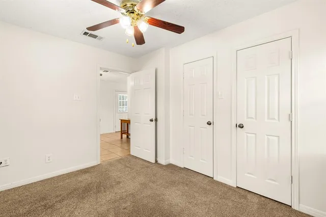 an empty room with a window and a fan