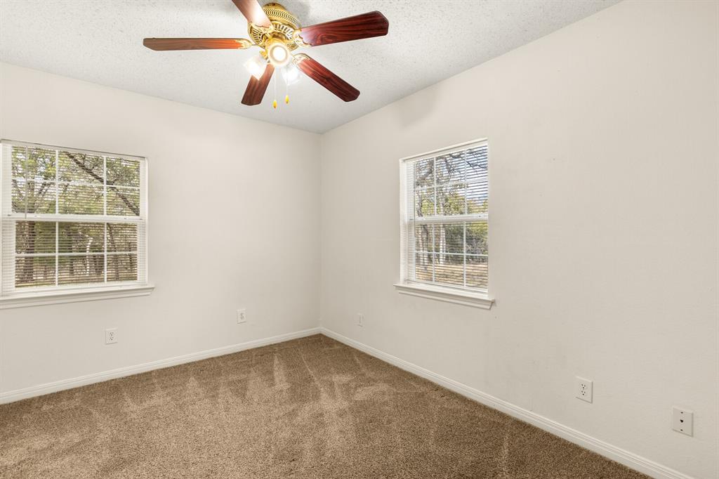 375 Panther Branch Road Valley Mills, TX 76689 - Photo 9 of 34 an empty room with a window and a fan