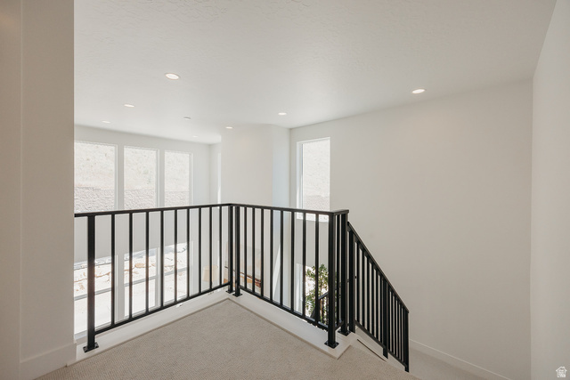 5902 Canyon Rim Road, Unit 620 Lehi, UT 84048 - Photo 61 of 78 Upper-level landing featuring a contemporary black metal railing and light-toned carpet flooring