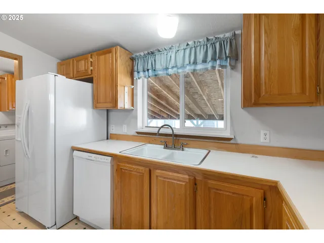 a kitchen with a sink a refrigerator and a cabinet