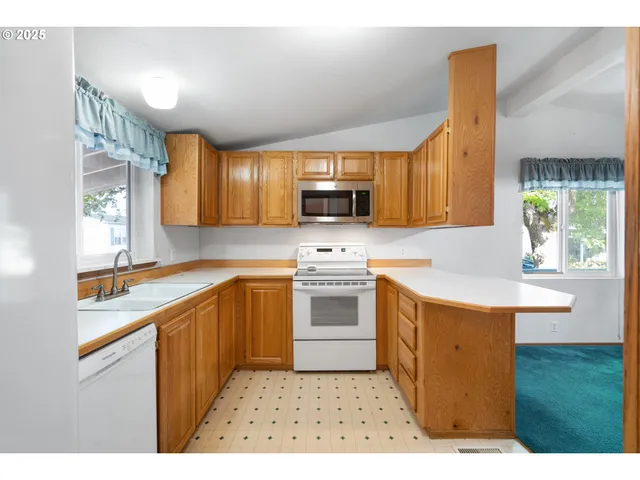 a kitchen with stainless steel appliances kitchen island granite countertop a sink stove and microwave