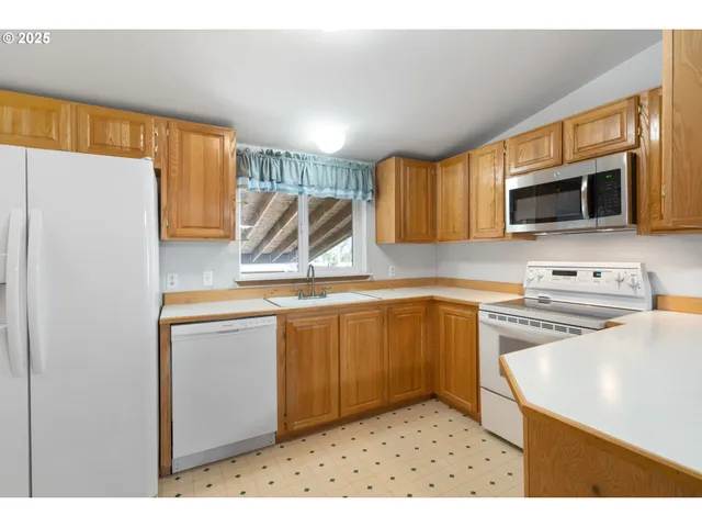 a kitchen with stainless steel appliances granite countertop a refrigerator a stove top oven a sink and dishwasher