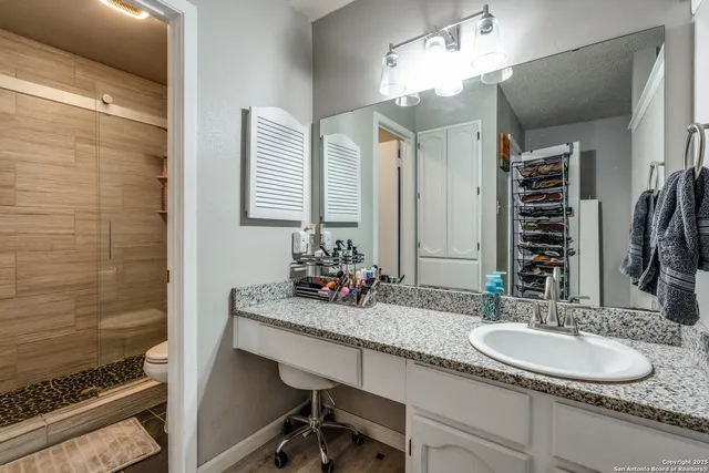 a bathroom with a granite countertop sink and a mirror