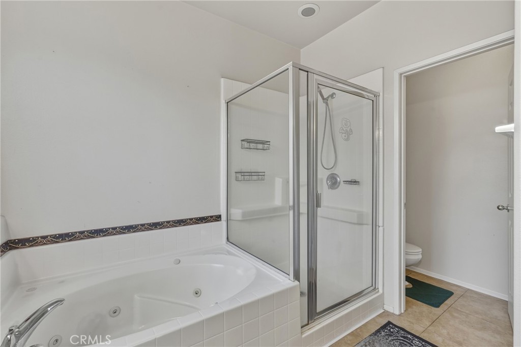 28853 Galaxy Way Menifee, CA 92586 - Photo 16 of 36 a bathroom with a bathtub and a shower
