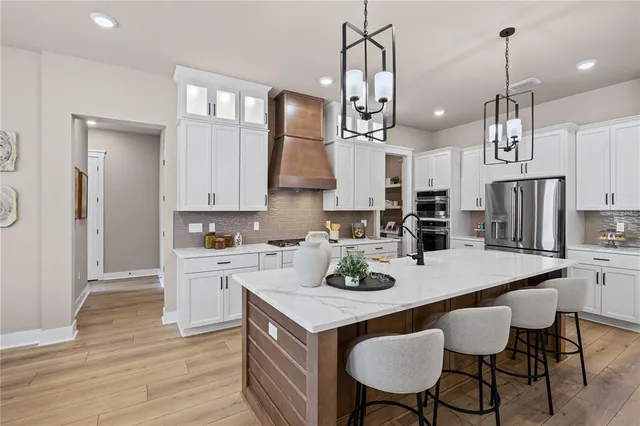 a kitchen with stainless steel appliances granite countertop a kitchen island a stove a table and chairs in it