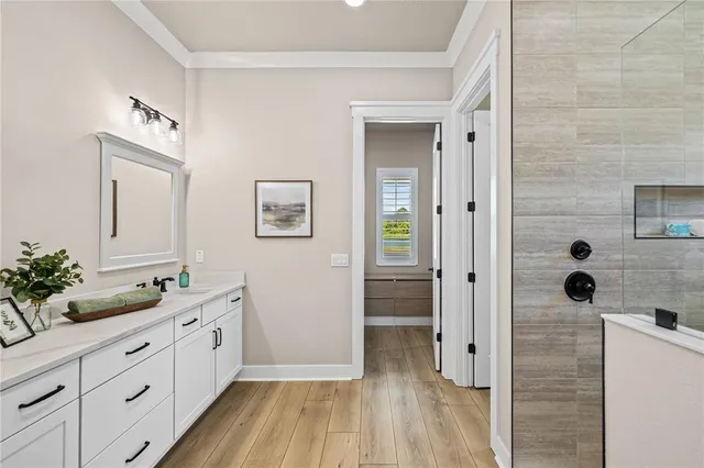 a spacious bathroom with a double vanity sink a mirror and shower