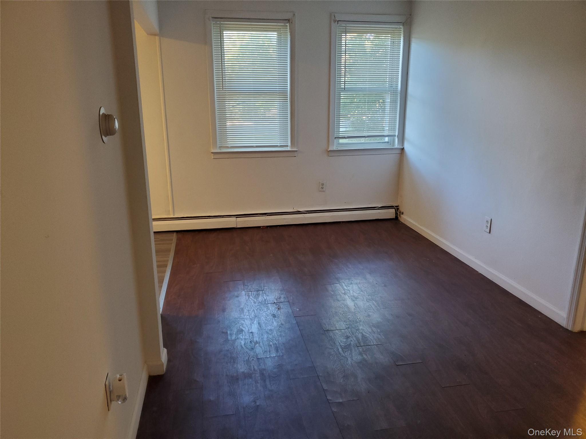 10 Sally Lane Ridge, NY 11961 - Photo 4 of 7 an empty room with wooden floor and windows