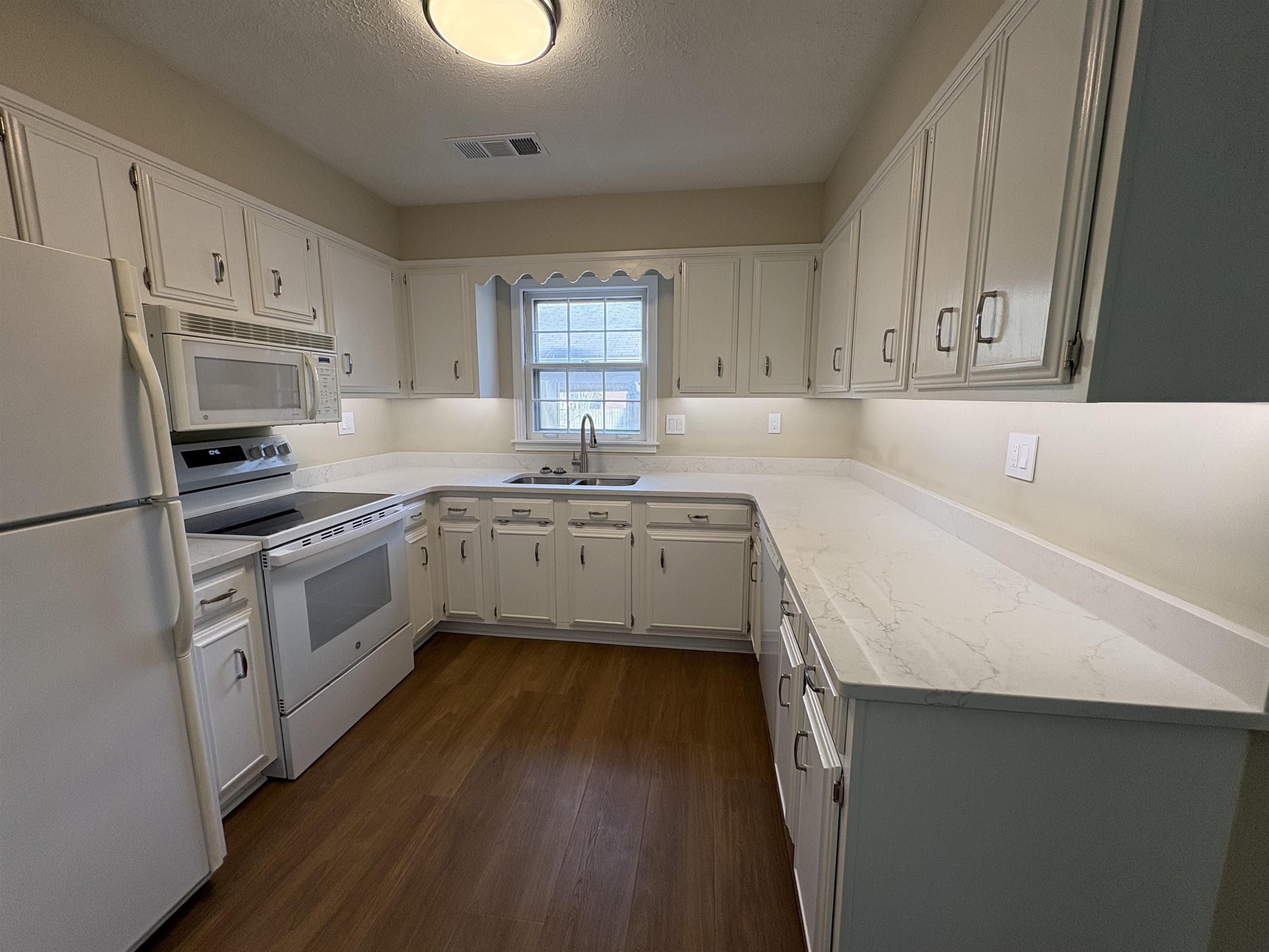 6985 Fords Station Road, Unit 41 Germantown, TN 38138 - Photo 7 of 20 Kitchen featuring white appliances, white cabinetry, dark wood-style floors, a textured ceiling, and light stone counters