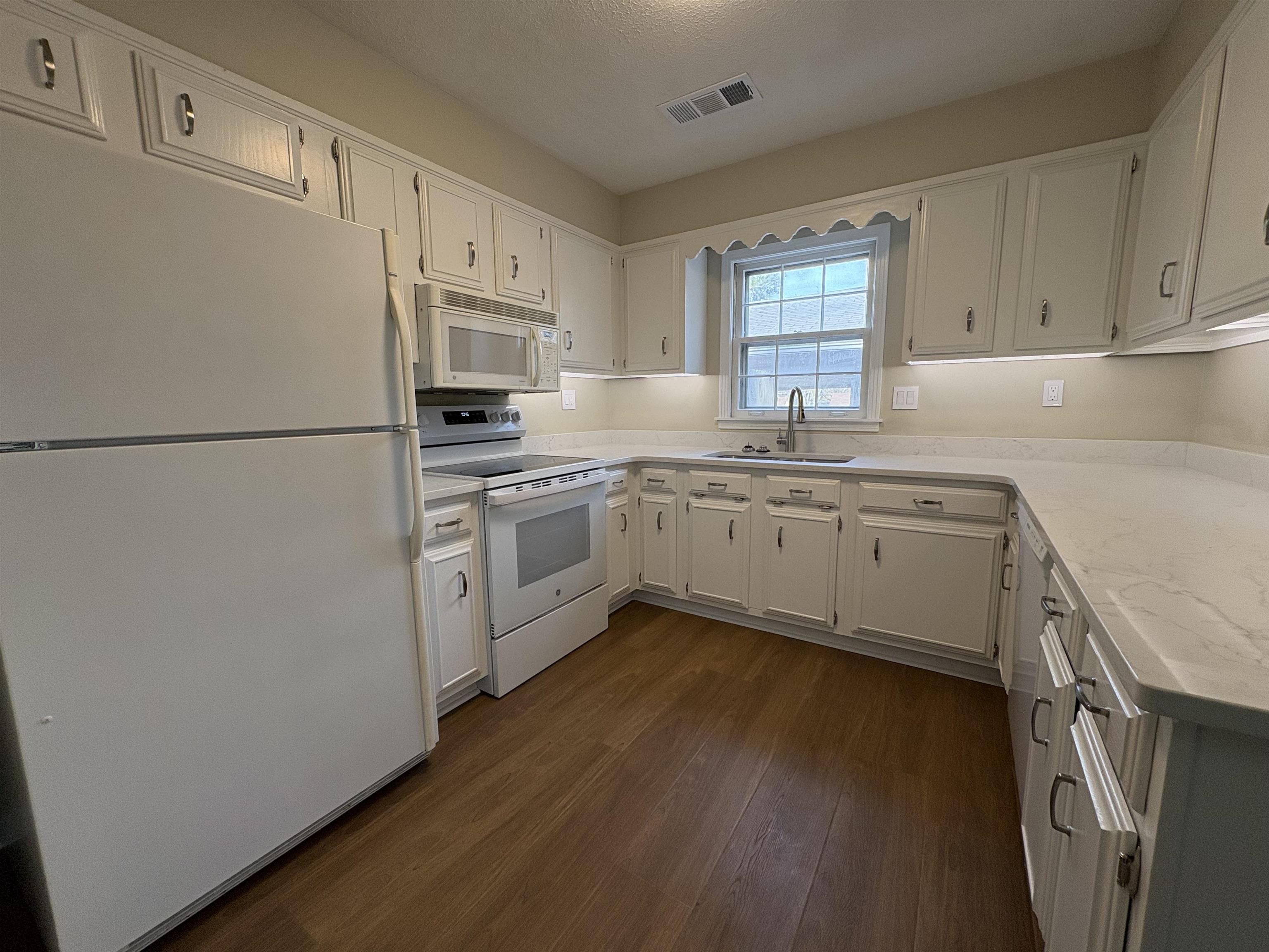 6985 Fords Station Road, Unit 41 Germantown, TN 38138 - Photo 8 of 20 Kitchen with white appliances, white cabinets, dark wood-style floors, and light stone counters