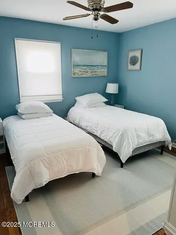 a bedroom with two beds and painting on the wall
