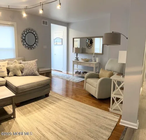 a living room with furniture and a wooden floor
